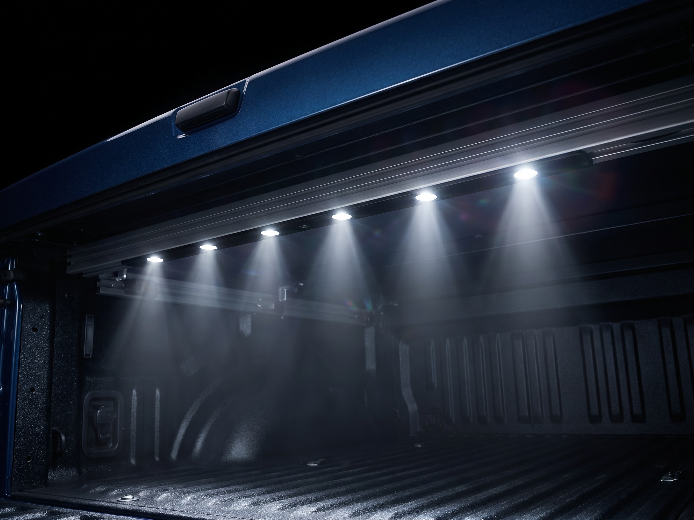 Built-in LED light strip illuminating the inside of a truck bed under a Coverjet tonneau cover